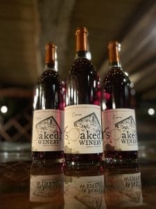 Close up of 3 bottles of a blush wine called "Cameo" sitting on a table.