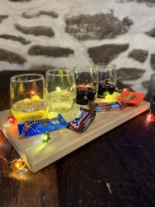 4 glasses of wine with a variety of candies in front of it sitting on a table.