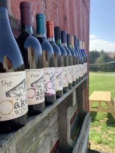 a row of wines from Soaked winery lined up on the side of a barn.